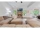 Spacious living room and dining area with a brick fireplace, large comfortable sofa, vaulted ceiling, and view of yard at 3455 Henderson Dr, Cumming, GA 30041