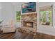 Cozy living room featuring a brick fireplace, mantel, and a relaxing armchair at 3455 Henderson Dr, Cumming, GA 30041