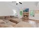 Spacious living room with a brick fireplace, large comfortable sofa, vaulted ceiling, and views of the outdoor greenery at 3455 Henderson Dr, Cumming, GA 30041