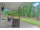 Covered patio with outdoor seating overlooking the backyard and wooded area at 3455 Henderson Dr, Cumming, GA 30041