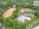 Expansive aerial view of equestrian center with riding arena and stables nestled among lush greenery at 4601 Tall Pines Nw Dr, Atlanta, GA 30327