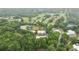 Aerial view of property featuring a golf course, tennis courts, swimming pool, and brick buildings surrounded by lush greenery at 4601 Tall Pines Nw Dr, Atlanta, GA 30327