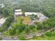 Aerial view of the school campus showing the school buildings, playground, and sports field, all surrounded by trees at 4601 Tall Pines Nw Dr, Atlanta, GA 30327