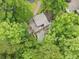 Aerial view of lush landscaping surrounding beautiful home with a stone pool and walkway at 4601 Tall Pines Nw Dr, Atlanta, GA 30327
