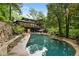 A private backyard retreat featuring a stone pool, meticulous landscaping, and mature trees at 4601 Tall Pines Nw Dr, Atlanta, GA 30327