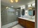 Modern bathroom with tile shower, stylish double vanity, and unique geometric mirrors at 4601 Tall Pines Nw Dr, Atlanta, GA 30327