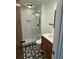 Bright bathroom features a modern tiled shower with glass surround and unique geometric tiled floor at 4601 Tall Pines Nw Dr, Atlanta, GA 30327