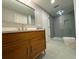 Modern bathroom featuring a wooden vanity, sleek sink, large mirror, and walk-in shower with blue tile at 4601 Tall Pines Nw Dr, Atlanta, GA 30327