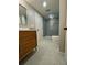 Modern bathroom featuring a wooden vanity, sleek sink, large mirror, and walk-in shower with blue tile at 4601 Tall Pines Nw Dr, Atlanta, GA 30327