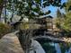 Modern home exterior with multi-level decks and an inground pool surrounded by lush landscaping at 4601 Tall Pines Nw Dr, Atlanta, GA 30327