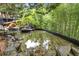Relaxing backyard pond with a small stone waterfall feature surrounded by lush landscaping at 4601 Tall Pines Nw Dr, Atlanta, GA 30327