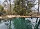 Backyard pool with rock accents surrounded by lush trees providing a calming outdoor space at 4601 Tall Pines Nw Dr, Atlanta, GA 30327