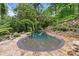 Serene backyard pool surrounded by stone landscaping and mature trees, creating a private oasis at 4601 Tall Pines Nw Dr, Atlanta, GA 30327