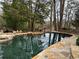 A gorgeous backyard pool surrounded by rock landscaping and mature trees at 4601 Tall Pines Nw Dr, Atlanta, GA 30327