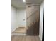 Modern staircase featuring wood steps, decorative vertical wood slats, and a white door at 4601 Tall Pines Nw Dr, Atlanta, GA 30327