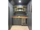 Stylish wet bar featuring a wooden countertop, grey cabinets, a sink, wine racks, and a mini-fridge at 4601 Tall Pines Nw Dr, Atlanta, GA 30327