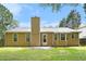 Home's rear exterior showing siding, windows, a patio, and a chimney against a green lawn at 7847 Dogwood Way, Douglasville, GA 30134