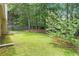 Lush backyard with a well-kept lawn, mature trees and flowering bushes at 7847 Dogwood Way, Douglasville, GA 30134