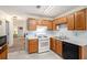 Functional kitchen featuring wood cabinetry, white appliances, and neutral tile flooring at 7847 Dogwood Way, Douglasville, GA 30134