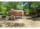 Rear view of the brick home showcases a basement entrance and raised deck with stairs at 2174 Rexford Dr, Decatur, GA 30034