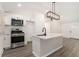 Modern kitchen featuring stainless steel appliances, white cabinetry, and a stylish island with pendant lighting at 2174 Rexford Dr, Decatur, GA 30034