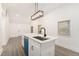 White kitchen island with a sink and black faucet, complemented by modern lighting at 2174 Rexford Dr, Decatur, GA 30034