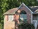 Close-up of a home's exterior showing red brick, a classic window, and a well-kept garden at 3230 Plymouth Rock Dr, Douglasville, GA 30135