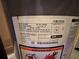 Close-up of a gas furnace with visible serial number, manufacturing date, and safety labels at 3230 Plymouth Rock Dr, Douglasville, GA 30135