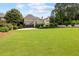 Expansive backyard with a well-maintained lawn, mature trees, and a sport court at 3495 Mill Bridge Dr, Marietta, GA 30062