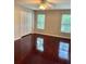 Spacious bedroom with hardwood floors, ceiling fan, and natural light from two windows at 121 Brittany Ct, Duluth, GA 30096