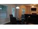 Cozy dining area with glass table, leather chairs, and backyard views with seating in the connected living room at 1504 Gallup Dr, Stockbridge, GA 30281