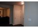 Hallway featuring two white interior doors with a glimpse into a living room area with a fireplace at 1504 Gallup Dr, Stockbridge, GA 30281
