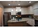 Bright kitchen featuring an island, stainless steel appliances, granite countertops, and white cabinetry at 1504 Gallup Dr, Stockbridge, GA 30281
