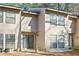 Inviting exterior of a neutral townhouse featuring a brick patio and multiple windows for natural light at 4870 Twin Lakes Trail, Atlanta, GA 30360