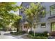 Attractive three story gray brick townhome with lush landscaping and trees lining the sidewalk at 126 Chestnut Cir, Atlanta, GA 30342