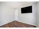 Empty bedroom featuring wood floors and a mounted flat screen television at 1478 Elena Dr, Mcdonough, GA 30253