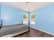 Bedroom featuring hardwood floors, light-blue walls, and natural light from the two windows at 1478 Elena Dr, Mcdonough, GA 30253