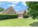 Brick home featuring mature landscaping, a symmetrical design, and a well-maintained lawn at 1478 Elena Dr, Mcdonough, GA 30253