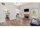 Bright living room with a brick fireplace, vaulted ceiling, and wood-look floors at 1478 Elena Dr, Mcdonough, GA 30253