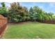 Spacious backyard with a lush green lawn and a well-maintained wooden fence at 216 Orchard Trl, Canton, GA 30115