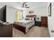 Well lit bedroom with a ceiling fan, large bed, night stand, and a small bookshelf at 216 Orchard Trl, Canton, GA 30115