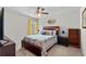Cozy bedroom with a ceiling fan, large bed, night stand, and window with bright yellow curtains at 216 Orchard Trl, Canton, GA 30115