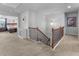 Upstairs hallway with wood banister overlooking railing and a bedroom with natural light and a decorative clock at 216 Orchard Trl, Canton, GA 30115