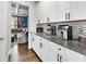 Butler's pantry showcases ample storage with white cabinets, dark hardware, and granite countertops at 216 Orchard Trl, Canton, GA 30115