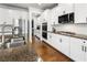 Modern kitchen features stainless steel appliances, granite countertops, and white cabinets with black hardware at 216 Orchard Trl, Canton, GA 30115