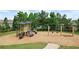 Community playground with slides and swings on a wood chip surface, surrounded by mature trees at 216 Orchard Trl, Canton, GA 30115