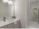 Bright bathroom featuring a single vanity, large mirror, and neutral tiling at 3600 Goldenrod Dr, Alpharetta, GA 30005