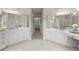 Spacious bathroom features dual vanities, a wide mirror, white cabinets, and an open doorway to an adjoining room at 3600 Goldenrod Dr, Alpharetta, GA 30005