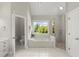 Well-lit bathroom featuring a soaking tub under a window, a glass-enclosed shower, and a separate toilet room at 3600 Goldenrod Dr, Alpharetta, GA 30005