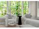 Bright bedroom sitting area featuring two comfy chairs, a small table, and a large window with scenic outdoor views at 3600 Goldenrod Dr, Alpharetta, GA 30005